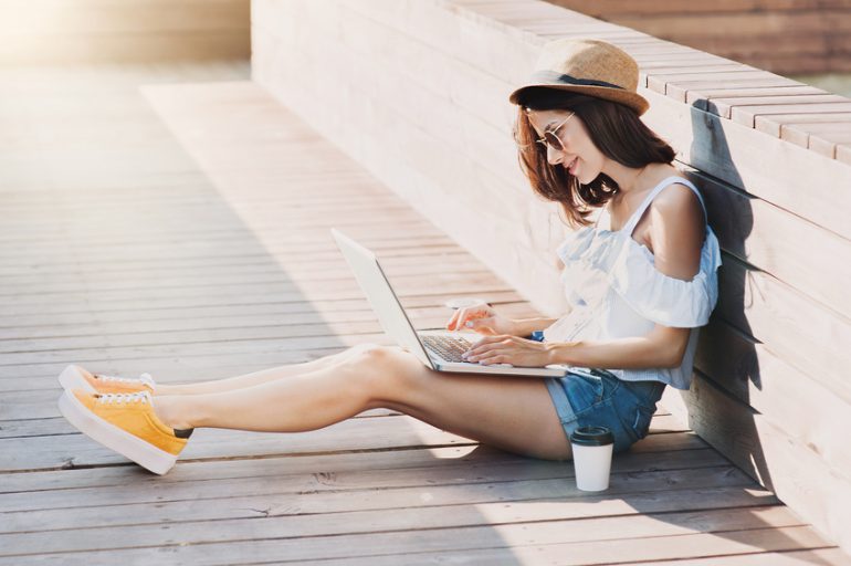 Blogger Girl using Laptop outdoors for Storytelling